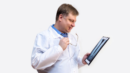 Male doctor in white coat with an x-ray in his hands, white background.の写真素材