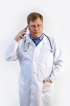 The doctor shows with gestures that he is calling on a smartphone concept of a medical consultation on the phone.の写真素材