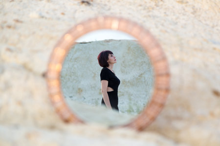 Mirror on the sand with reflection of woman creativity and fantasy.の写真素材