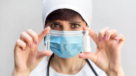 Close-up portrait of a woman doctor with medical drugs in her hands.