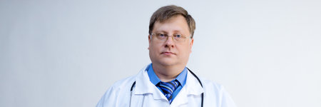 Portrait of a male doctor aged 40-44, for advertising and sign banner.の写真素材