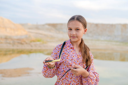 A teenage girl plays with a snake, holding it in her hands. Children and snakes in the wild.の写真素材