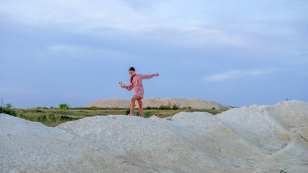 A teenage girl photographs the sunset on a mobile phone, recreation and entertainment for children nature.の写真素材