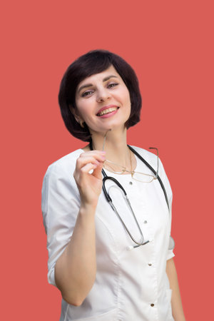 Woman doctor brunette with short haircut on red background.の写真素材