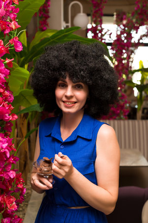 Middle aged woman with curly black hair eats ice cream.,の写真素材