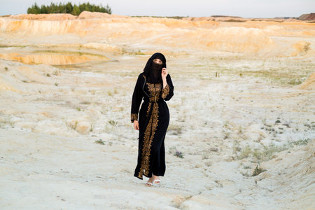 Muslim woman walking in the desert area around the city.の写真素材