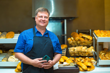 Entrepreneur near the counter with his flour products, seller of bread and rolls.の写真素材