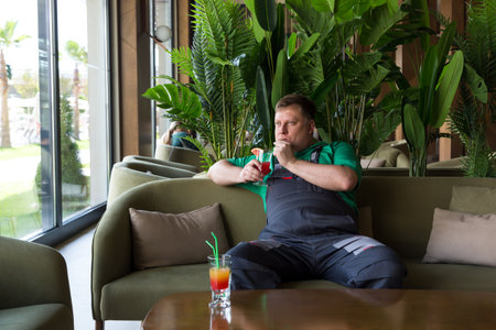 Worker drinking a cooling cocktail during lunch break while sitting sofa.の写真素材