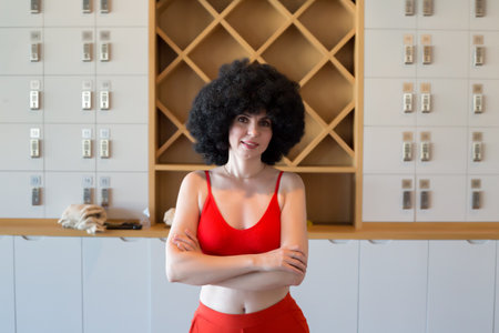 Athletic woman red top stands with her arms folded on her chest.の写真素材
