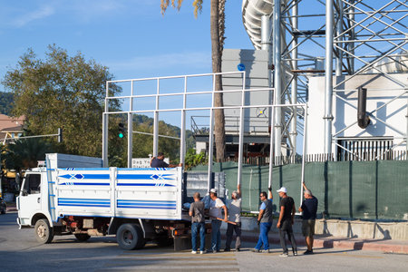 Kemer, Turkey - September 26, 2023: A group of men unload a truck. Editorial.のeditorial素材