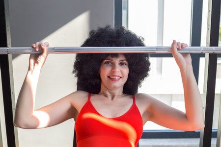 Portrait of middle aged woman lifting weights in gym during training.の写真素材