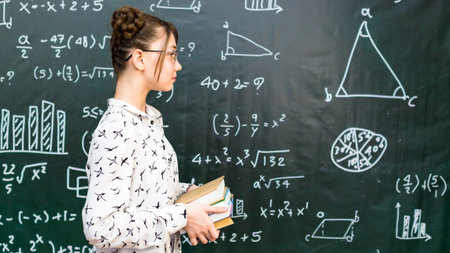 Girl schoolgirl with 4 books in her hands, concept school life preparing for exams.