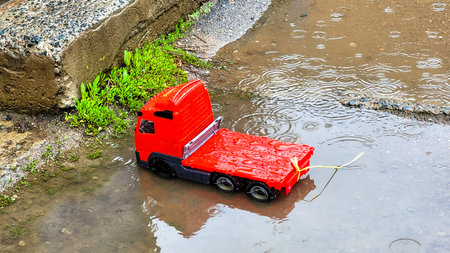 A children toy car was left near the entrance to house. Car for children in the rain in a deep...