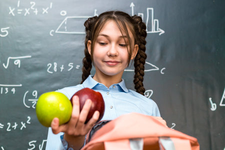 A teenage schoolgirl took out apples a snack during a break between lessons.