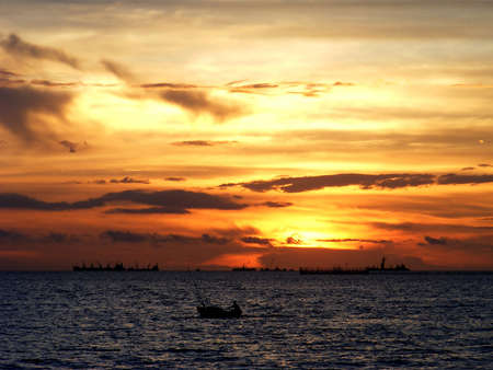 Fishing boat on the sea and sunsetの写真素材