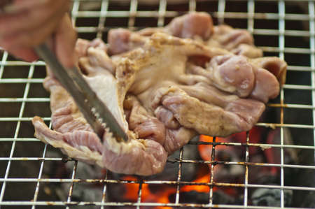 Grilling a steak on the barbecueの写真素材