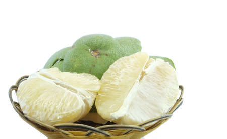 Green pomelo citrus fruit on wood Basket white backgroundの写真素材