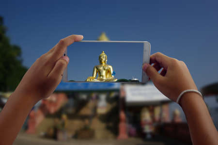 travel concept take photography buddha statue at Thailand by phoneの写真素材