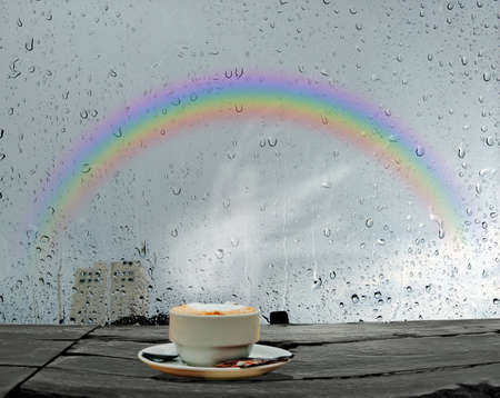 coffee on morning and sky rainbow in rainy seasonの写真素材