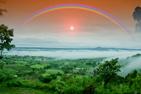 Sky rainbow and misty mountain in the distance and sunsetの写真素材