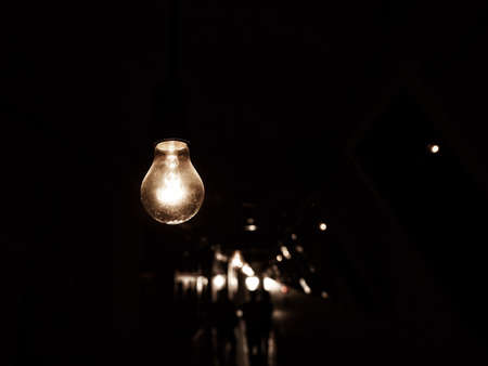 Hanging light bulb in darknessの写真素材