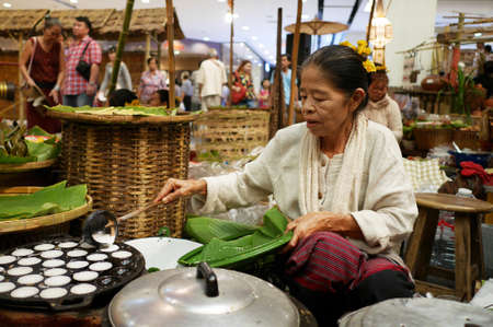 BANGKOK THAILAND April 5, 2015 - Old lady made Thai sweetmeat call kanom krok coconut rice cake for sale.のeditorial素材