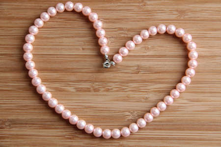 A love heart shape made of a soft pink pearl necklaceの写真素材