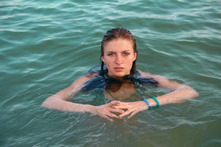 Close up shot of a young female floating in waterの写真素材