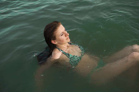 Close up shot of a young female floating in waterの写真素材