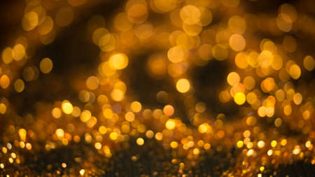 Golden lights bokeh defocus abstract background. Gold Festive Christmas. Glitter twinkled bright...