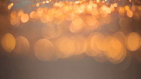 Golden lights bokeh defocus abstract background. Gold Festive Christmas. Glitter twinkled bright...