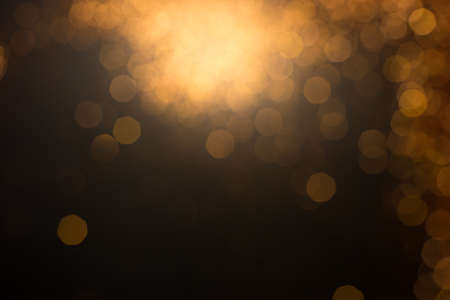 Golden lights bokeh defocus abstract background. Gold Festive Christmas. Glitter twinkled bright...
