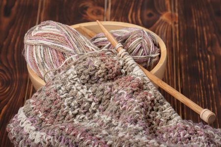 Knitting of Scarf or Snood. Yarn Balls. Wooden Knit Needles.