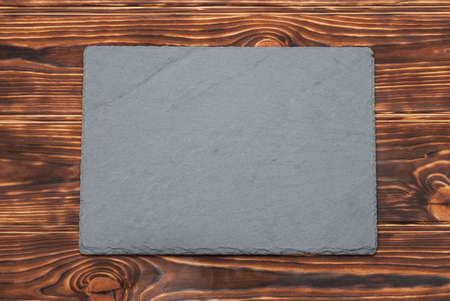 Flat Slate Stone On Wooden Background.の写真素材