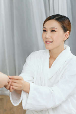 	A spa young woman handing out a bank card	
