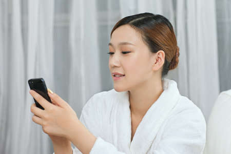 	A young woman talking by cell phone in spa salon	の写真素材