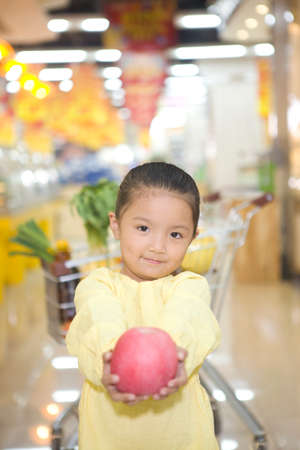 A cute little girl in the supermarketの写真素材
