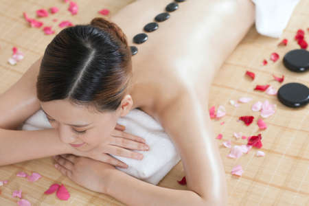 young lady doing stone massageの写真素材