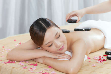 young lady doing stone masssageの写真素材