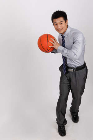 A business man playing basketballの写真素材