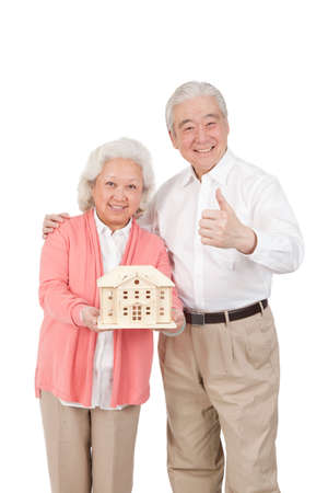Senior couple holding building modelの写真素材