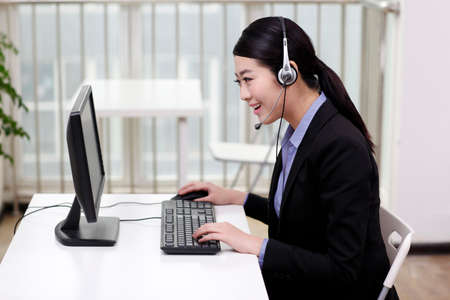 Businesswoman with a headset using computer