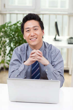 Close-up of a businessman using a laptop in an officeの写真素材
