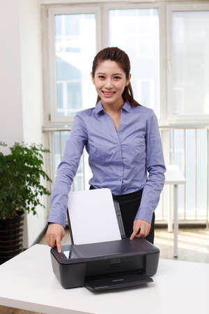 Businesswoman with printer in office