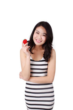 Young woman in a striped dress holding strawberryの写真素材