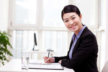Businesswoman writing on portfolioの写真素材