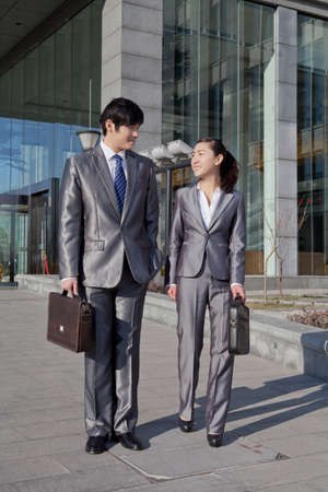 Businessman and businesswoman walking to workの写真素材