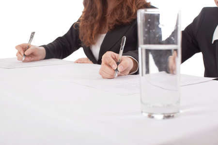 Glass of water on table,business people in backgroundの写真素材