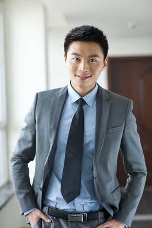 Portrait of young businessman in corridorの写真素材