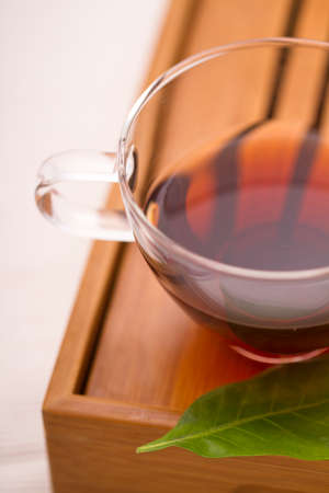 A cup of chinese tea with a piece of leafの写真素材